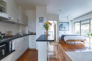 a kitchen with a sink and a bed in a room at St Kilda Studio Apartment walking distance to the beach in Melbourne