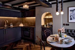 a kitchen with a table with chairs and a sink at The Knitters House - Luxury 3 Bedroom Property in Nottingham +27 photos