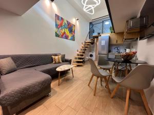 a living room with a couch and a table at City Center Loft With Private Parking in Kavála
