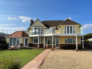 a large yellow house with a large yard at Barton on Sea self contained, stunning sea views in Barton on Sea