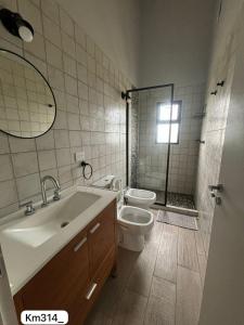 Un baño con lavabo, inodoro y ducha. en Terramar, en Las Toninas