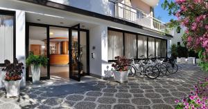 een groep fietsen geparkeerd naast een gebouw bij Hotel Helios in Diano Marina
