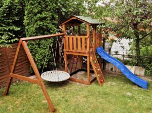 a playground with a swing and a slide at Béri Apartman in Siófok