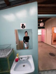 a woman is taking a picture of a bathroom sink at Stay&Explore Okuma,Yanbaru National Park,Cape Hedo in Kunigami +41 photos