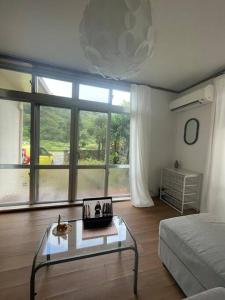 a living room with a bed and a glass table at Stay&Explore Okuma,Yanbaru National Park,Cape Hedo in Kunigami
