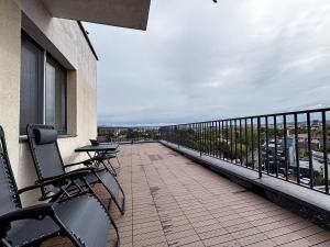 Un balcón de un edificio con dos sillas y una barandilla. en Wonder Apartment With Terrace, en Cluj-Napoca