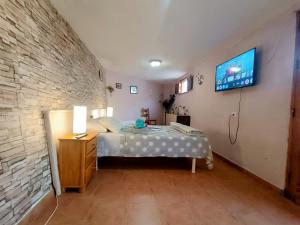 a bedroom with a bed and a tv on the wall at Villa Margarita in Santa Lucía