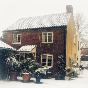 a brick house with snow on the roof at Southwell Holiday Cottage - Lavender Cottage in Southwell