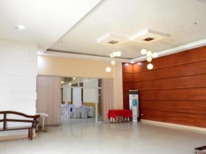 una grande stanza con una panca rossa e un tavolo di Big Daddy Hotel and Convention Center a Butuan