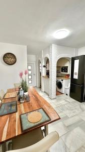 eine Küche und ein Wohnzimmer mit einem Holztisch und einem Kühlschrank in der Unterkunft Casa Costa del Sol Beach&Golf,Marbella in Sitio de Calahonda