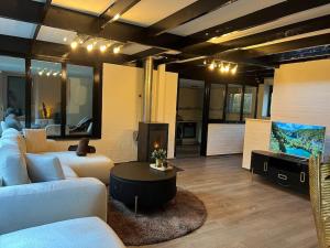 a living room with a couch and a tv at Etwee Vakantiehuis in Lanaken