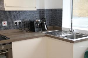 コルチェスターにあるEast Street Haven - Modern Apartment in Colchesterのシンクと電子レンジ付きのキッチン