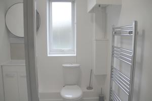コルチェスターにあるEast Street Haven - Modern Apartment in Colchesterのトイレと窓のある白いバスルーム