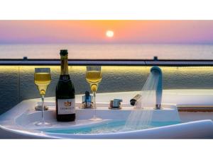 a hot tub with two glasses of wine and a bottle of champagne at OCEAN FRONT TATEYAMA - Vacation STAY 35718v in Tateyama
