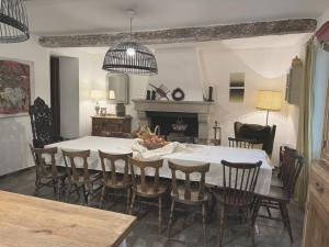 a dining room with a white table and chairs at Mas dans la campagne pour loisirs et télétravail in Sarrians