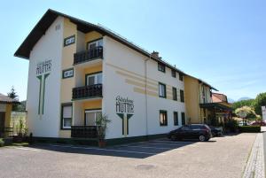 a building with a car parked in a parking lot at Hotel Garni Gästehaus Hutter in Unterburg am Klopeiner See