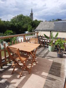 a wooden table and chairs on a deck at Maisonnette pour halte angevine in Les Ponts-de-Cé