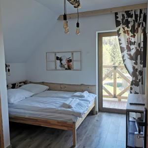 a bedroom with a bed and a large window at Domek Za Skałą in Kamesznica +29 photos