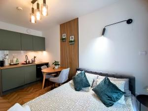 a bedroom with a bed and a table and a kitchen at AmaMolto Select - włoskie apartamenty, bezpłatny parking in Wrocław