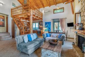 ein Wohnzimmer mit einer Couch und einer Treppe in der Unterkunft Villa Acqua, a luxury villa with private pool, 10 mins drive from the beach in Marantochori