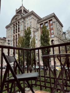 eine Bank, die vor einem großen Gebäude sitzt in der Unterkunft Kyiv Khreschatyk 27 Apartment in Kiew