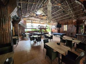 a restaurant with tables and chairs in a room at MB's Garden Inn in Mactan