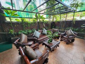 a screened in porch with chairs and a table at MB's Garden Inn in Mactan
