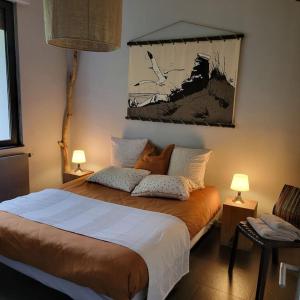 a bedroom with a large bed with two lamps at Au vert chez Diane in Sparsbach
