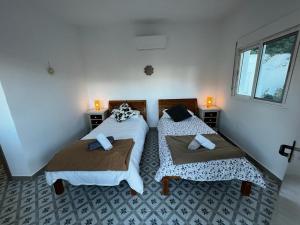 a bedroom with two beds and a window at Villa Trompetilla Montes de malaga with Yoga studio and Spa in Málaga +36 photos