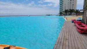 a swimming pool with boats on a wooden dock at Arrecife in La Serena