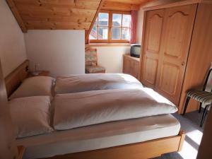a bedroom with two beds and a chair at Hotel Bachmann in Villabassa