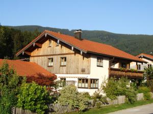 una grande casa in legno con tetto rosso di Apartment Andrea a Inzell