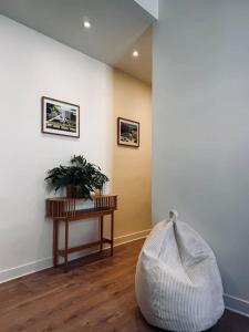 a living room with a table and a plant on the floor at Les Dunes Appartement Cosy 200m de la mer in Le Touquet-Paris-Plage