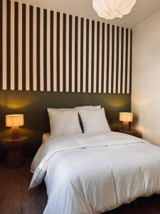 a bedroom with a large white bed with two lamps at Les Dunes Appartement Cosy 200m de la mer in Le Touquet-Paris-Plage