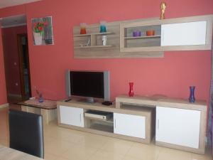 a living room with a tv on a wall at Playa Sol Mediterranea in Denia