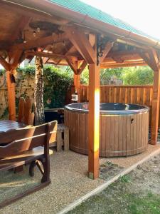 wanna z hydromasażem pod drewnianą pergolą z ławką w obiekcie Rita Apartman w Gyenesdiás +37 zdjęć