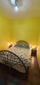 a bedroom with a bed with yellow walls and two lights at Apartament Anahita in Sinaia +16 photos