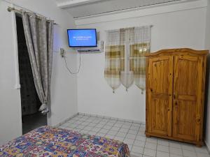 Un televizor și/sau centru de divertisment la Bungalow charmant au Moule avec vue sur jardin