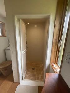 a bathroom with a walk in shower next to a door at GETO House in Washiaimori +35 photos