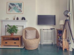 a living room with a chair and a television on a wall at Fantastic 3 Bed Beachfront Flat with Seaview in Margate