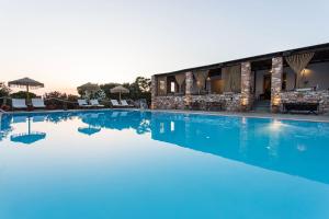a pool at a resort with blue water at Parosland Hotel in Aliki