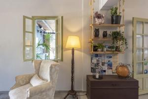 a living room with a chair and a lamp at Parosland Hotel in Aliki
