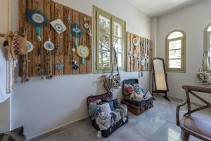 a room with plates on the wall and a chair at Parosland Hotel in Aliki