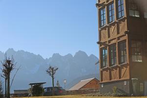 a tall building with mountains in the background at Haus Leopold in Gosau