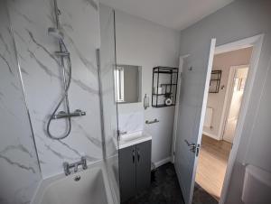 un bagno con doccia e lavandino di Hoot Hollow - Hot Tub Hideaway a Heacham Altre 85 foto