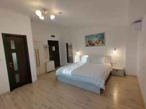 a bedroom with a white bed and a wooden floor at La Amy in Pangarati +55 photos