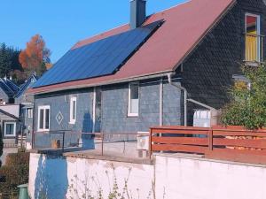 a house with solar panels on top of it at Ruhiges Ferienhaus mit viel Platz und Ladestation für E-Auto in Masserberg
