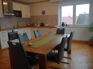 a kitchen with a wooden table with chairs around it at Ruhiges Ferienhaus mit viel Platz und Ladestation für E-Auto in Masserberg +9 photos