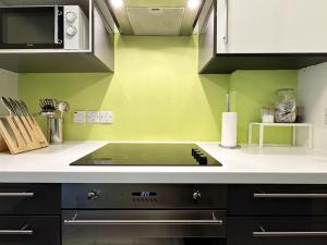 a kitchen with green walls and a stove top oven at Oliver's Place in Holborn - 2 Double Beds, 1 Sofa Bed, Great Location in London +31 photos