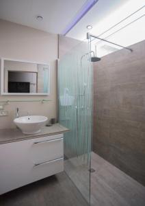 a bathroom with a glass shower and a sink at Git Émoi in Estaimpuis